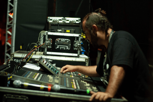 Technicien du spectacle réglant une console de mixage lors d’un concert