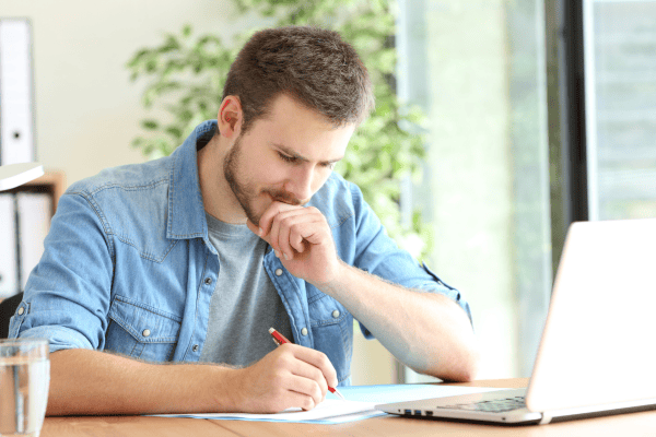 Jeune entrepreneur examinant des documents administratifs lors de la création de son entreprise